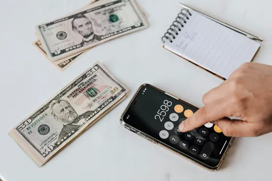 Cash and a calculator app on a phone